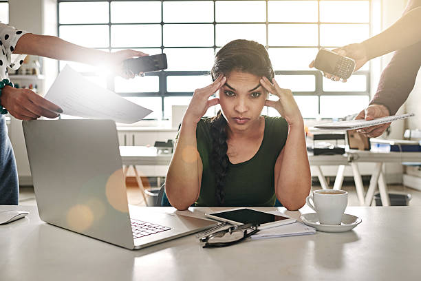 Work overload Shot of a stressed out businesswoman surrounded by colleagues needing help time pressure stock pictures, royalty-free photos & images