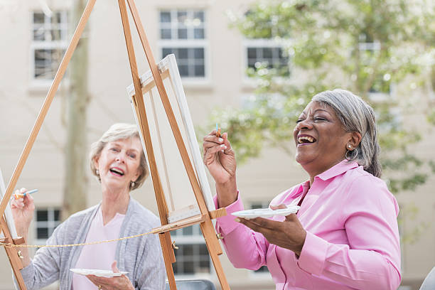 istock Two senior women having fun painting in art class 529066942