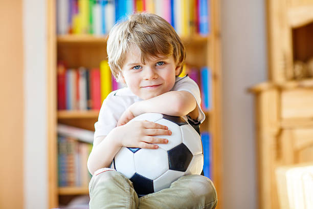 istock Kid boy watching soccer or football game on tv 529068652