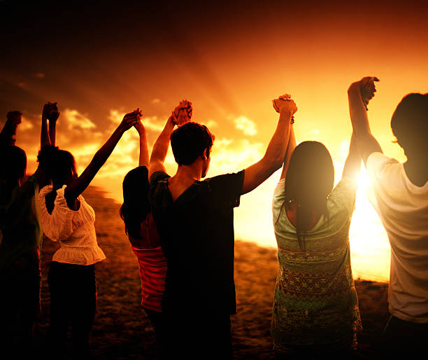 volunteer ensemble au crépuscule - holding hands human hand holding multi ethnic group photos et images de collection