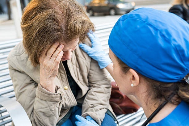 Female doctor assisting a senior woman Female doctor assisting a senior woman in the street infarction photos stock pictures, royalty-free photos & images