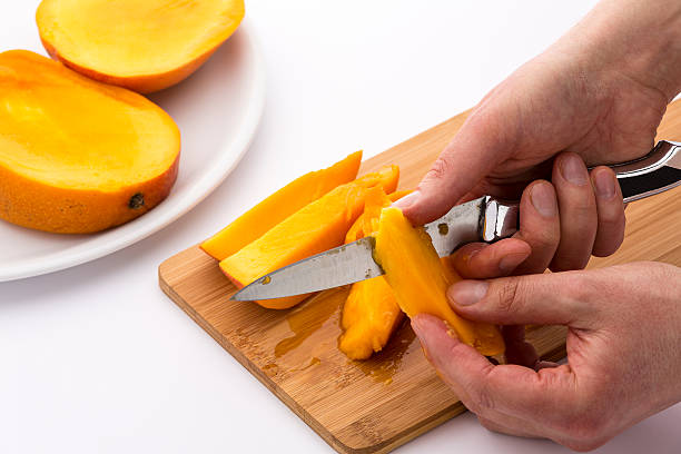 istock Close-up Of Two Hands Peeling Juicy Mango Pieces 529069549
