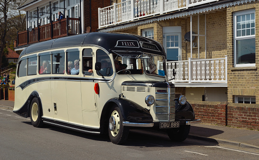 Felixstowe, Suffolk, England - May 01, 2016:  Vintage cream and black Bedford bus with passengers  being driven along street.