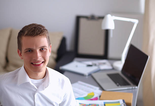 istock Smiling businessman with folder sitting in the office 529071229