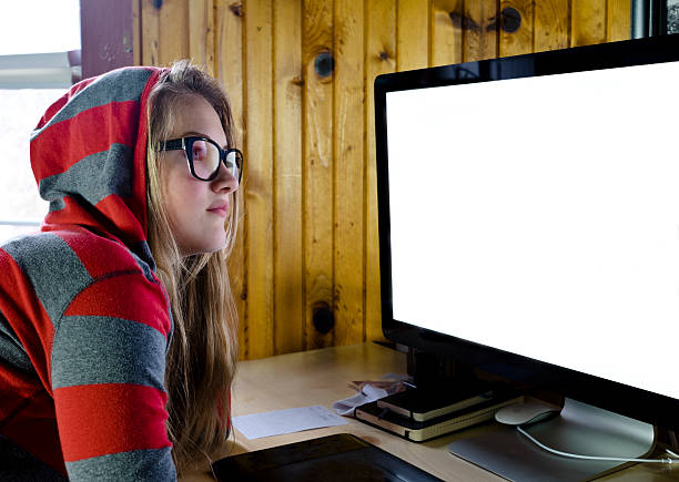 Young woman or teen working at a computer screen.