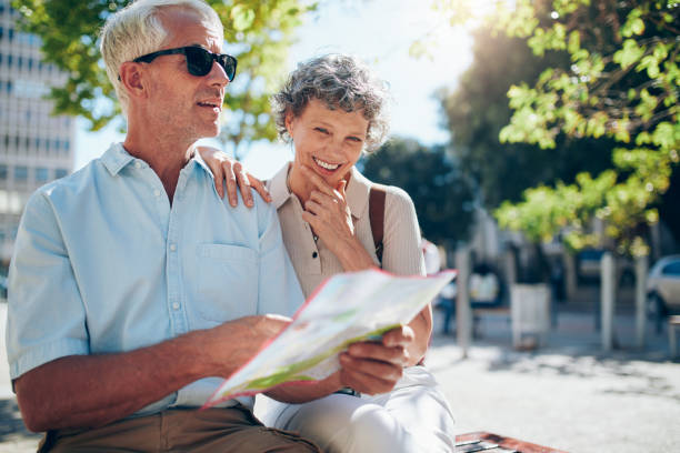 pareja de edad mayor utilizando un mapa de la ciudad de ubicación - tourist map men holding fotografías e imágenes de stock