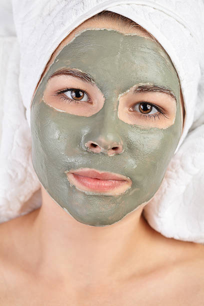 istock Attractive young woman with spa applied mud clay mask. 529077048