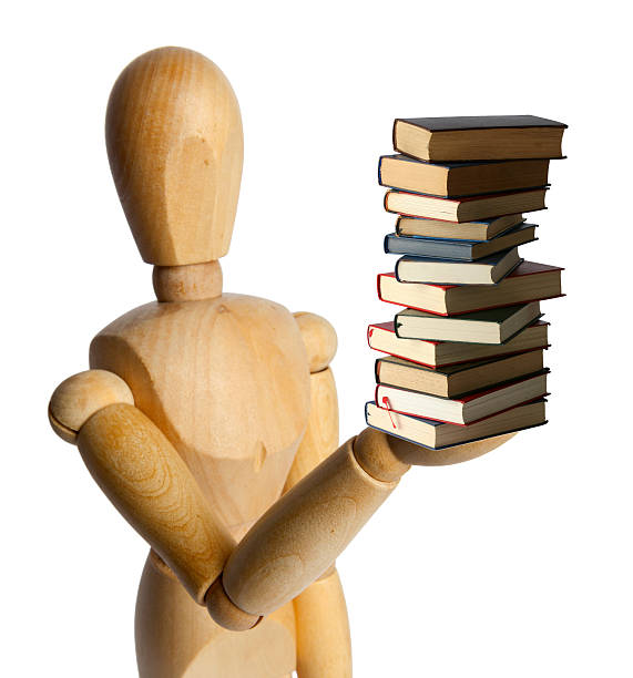 本の山を持つ木製の人形 - mannequin book education doll ストックフォトと画像