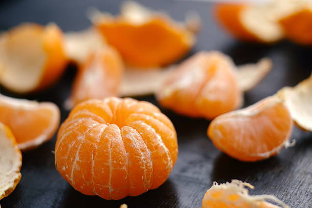 istock Cantels of mandarins with peels on a dark table 529077738