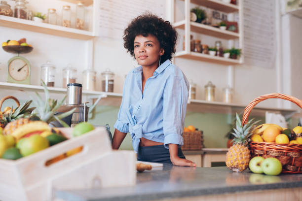 istock Attractive young woman standing at juice bar counter 529078558