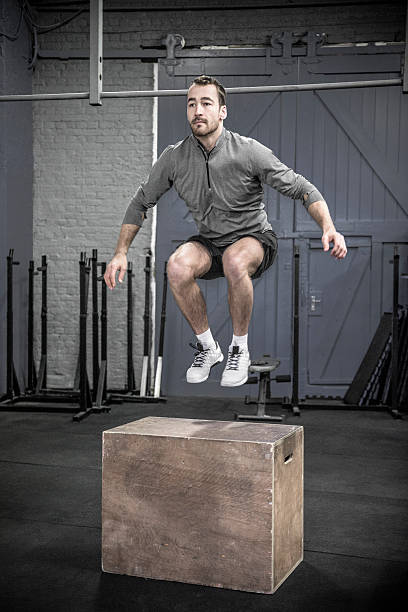 istock Mid adult man doing box jumps in cross training class 529078722