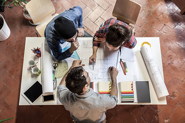 Teamwork. Three young architects working on a project Working Group. Three young architects working on a project at a table in the study drawing board stock pictures, royalty-free photos & images