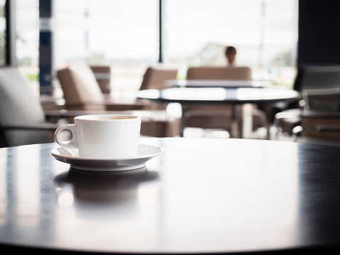 Coffee cup on table with blurred people in Restaurant shop cafe Interior seats background