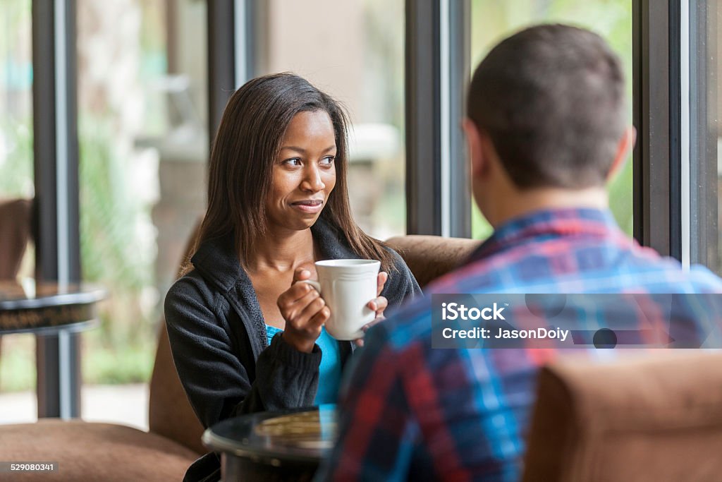 Good Friends and Good Coffee Attractive African American women have a good time with a close friend drinking good coffee. Friendship Stock Photo