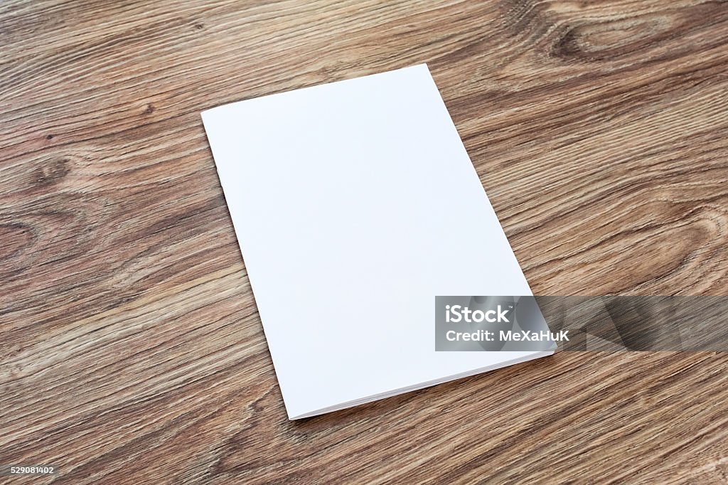 Blank of brochure is on a wooden desk. Blank of brochure is on a wooden desk. Template for your design.  Table Stock Photo