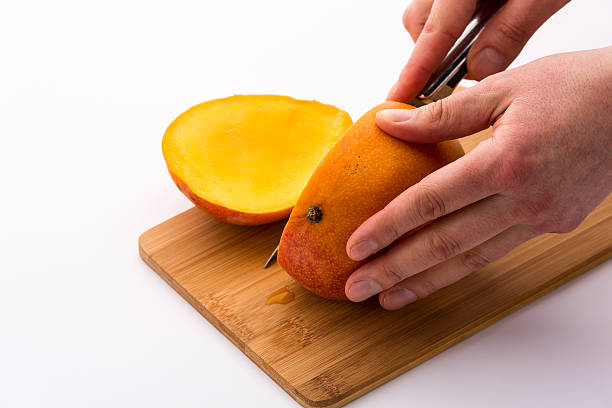 istock Third Of A Mango Sliced Off In A First Cut 529081611