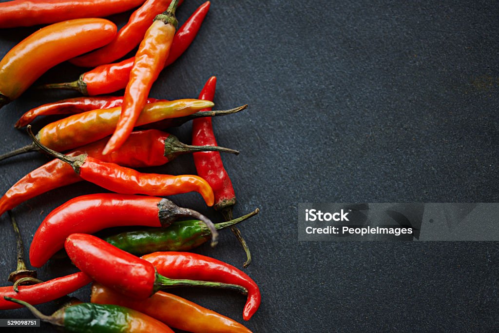 The hotter, the better High angle shot of fresh red chillies on a kitchen counter Backgrounds Stock Photo