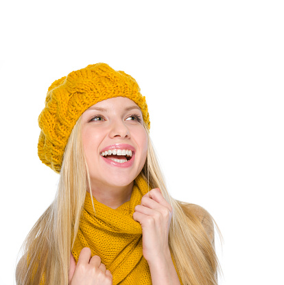 Smiling girl in autumn clothes looking on copy space