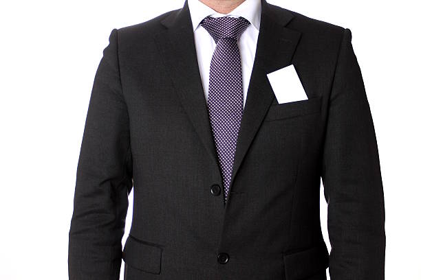 Man wearing a charcoal grey buisines suit with white shirt and lilac tie with business card
