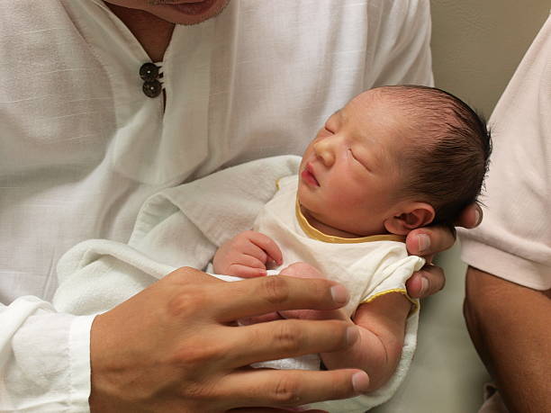 nouveau-né bébé dans la main - baby yawning asian ethnicity newborn photos et images de collection