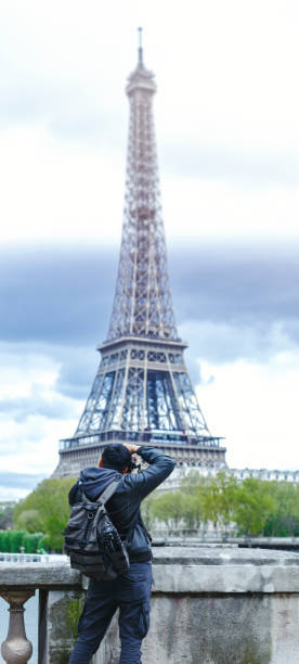 istock Photographer taking photo of the Eiffel Tower - vertical panoramic 529115414