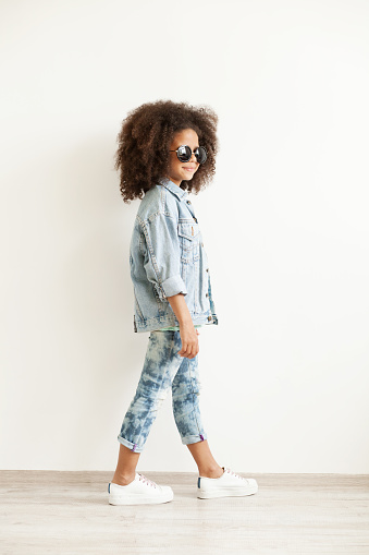 Beautiful stylish little girl in jean clothes