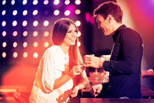 Portrait of well dressed couple enjoying cocktails  in a night club