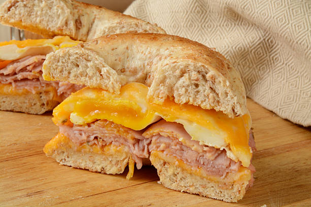 Bagel breakfast sandwich A ham, egg and cheese breakfast sandwich on a multi grain bagel colby cheddar stock pictures, royalty-free photos & images