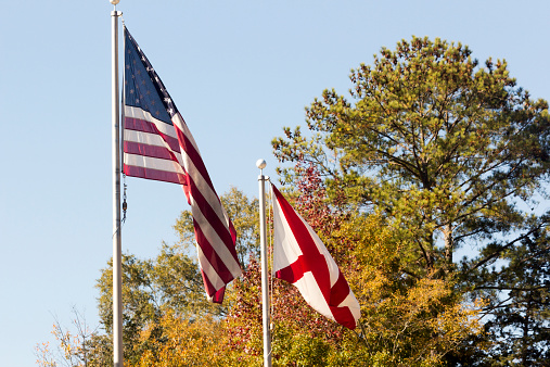 An American Flag and an Confederate flag on a fall background.