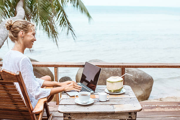 istock Young woman working on laptop with coffee and young coconut 529118078