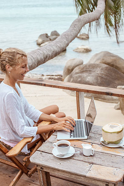 istock Young woman working on laptop with coffee and young coconut 529118212
