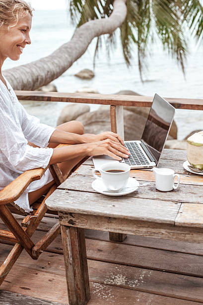 istock Young woman working on laptop with coffee and young coconut 529118780