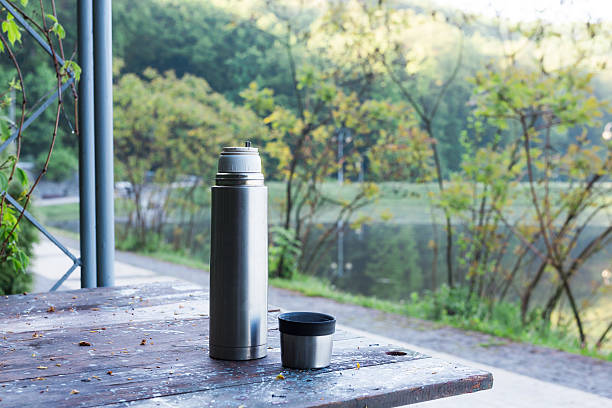 istock Thermos  and cup of coffee on wooden table 529118962