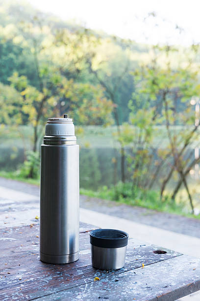 istock Thermos  and cup of coffee on wooden table 529119022