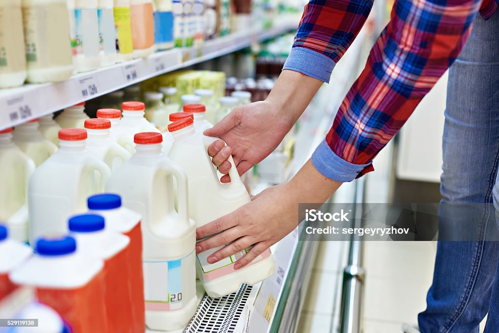 Woman shopping milk in store Woman shopping milk in grocery store Milk Stock Photo