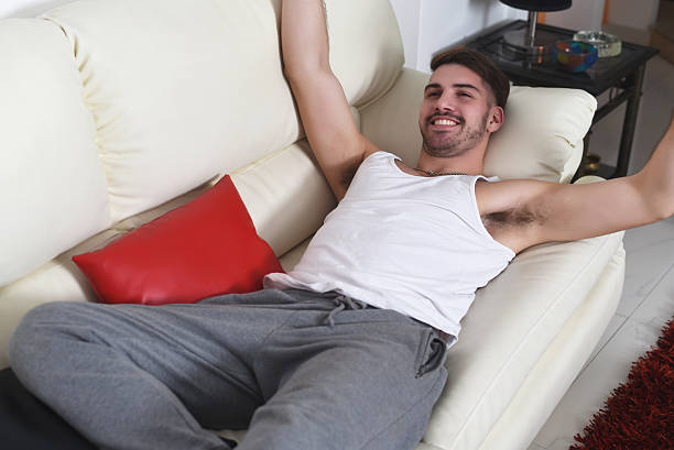 istock happy young man lying on couch and relaxing 529120390