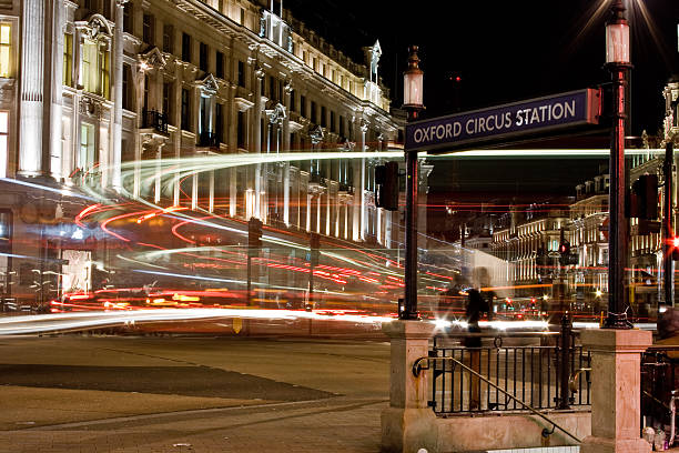 London, UK  - April 19, 2013: A view of Oxford Circus in central London at night. An entrance to the subway can be seen.