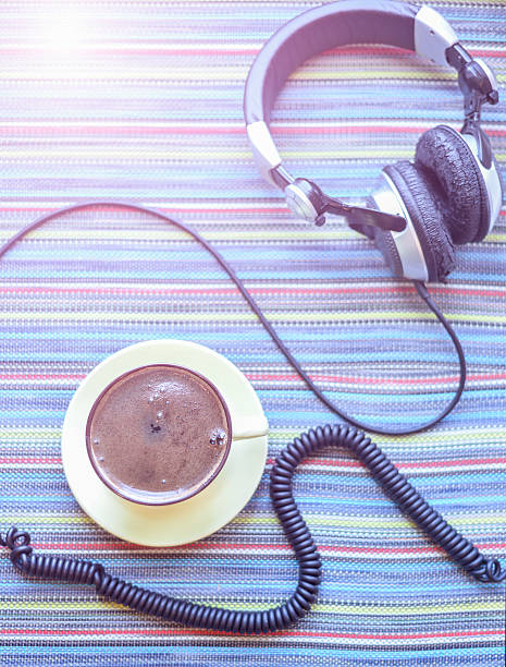 istock headphones and cup with coffee on the colorful tablecloth 529122218