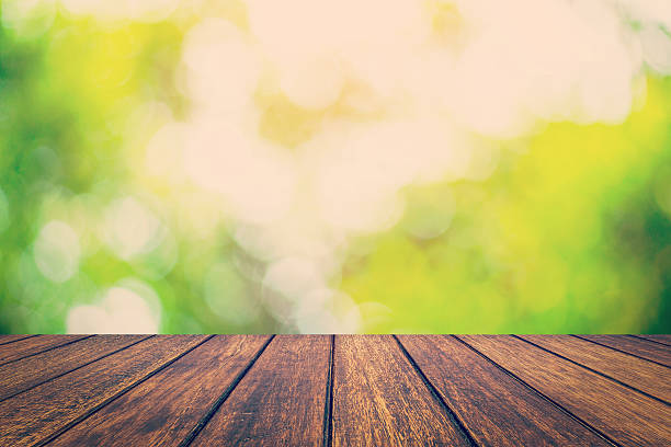 istock abstract blurred green bokeh and wood table background with spac 529124394