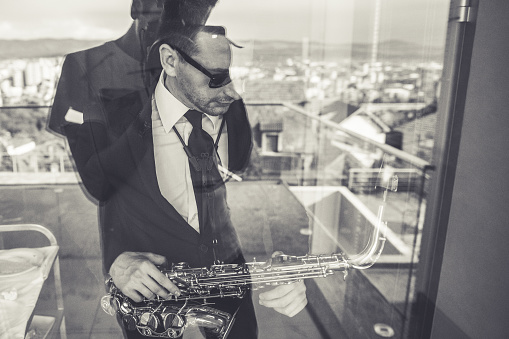 Saxophonist behind the glass door