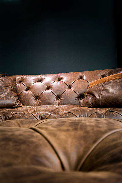 istock Detail of Vintage Brown Leather Sofa under Black Empty Wall 529126128