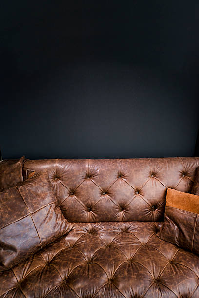 istock Detail of Vintage Brown Leather Sofa under Black Empty Wall 529126816