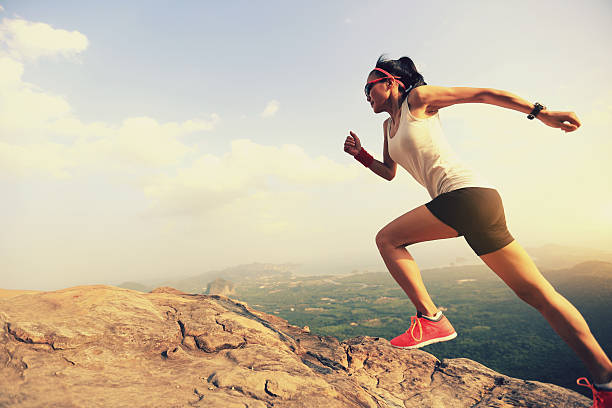 istock young woman trail runner running on mountain peak 529127496