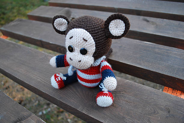istock Toy monkey sitting on the wooden boards. 529130304