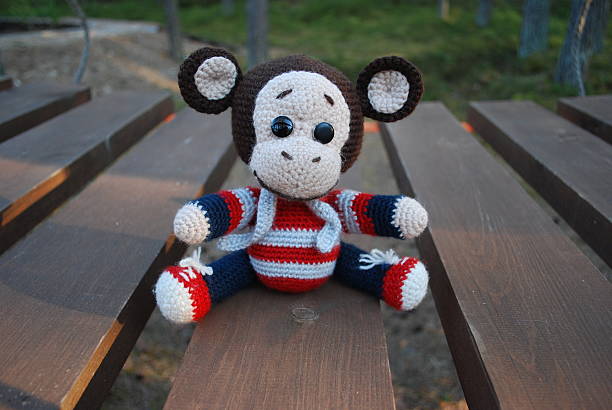 istock Toy monkey sitting on the wooden boards. 529130474