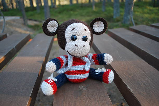 istock Toy monkey sitting on the wooden boards. 529130614