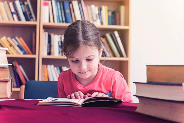 istock Small Girl in Old Library Reading Books 529132880
