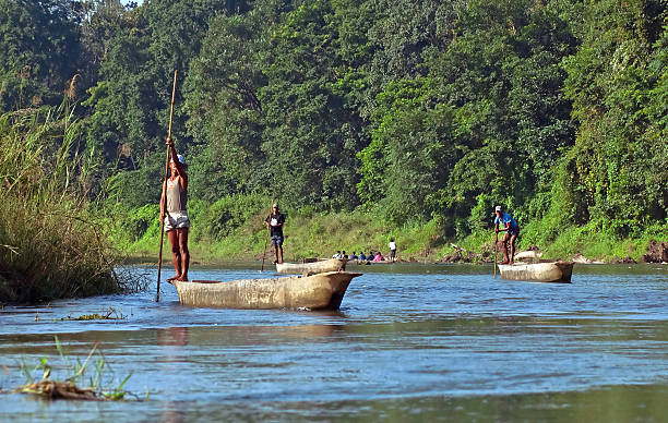 hombre locales de viaje en barco de remos en salvaje río - logboat fotografías e imágenes de stock