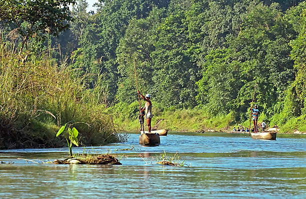 lokale mann sie von ruderboot im wild fluss - logboat stock-fotos und bilder