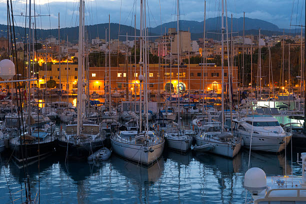 Palma de Majorca, Alcudia, Spain, Balearic Islands - October 16, 2018: luxury yachts in the harbor of the Mediterranean Sea at the night. Commercial docks, nighttime. Europe, European Union.